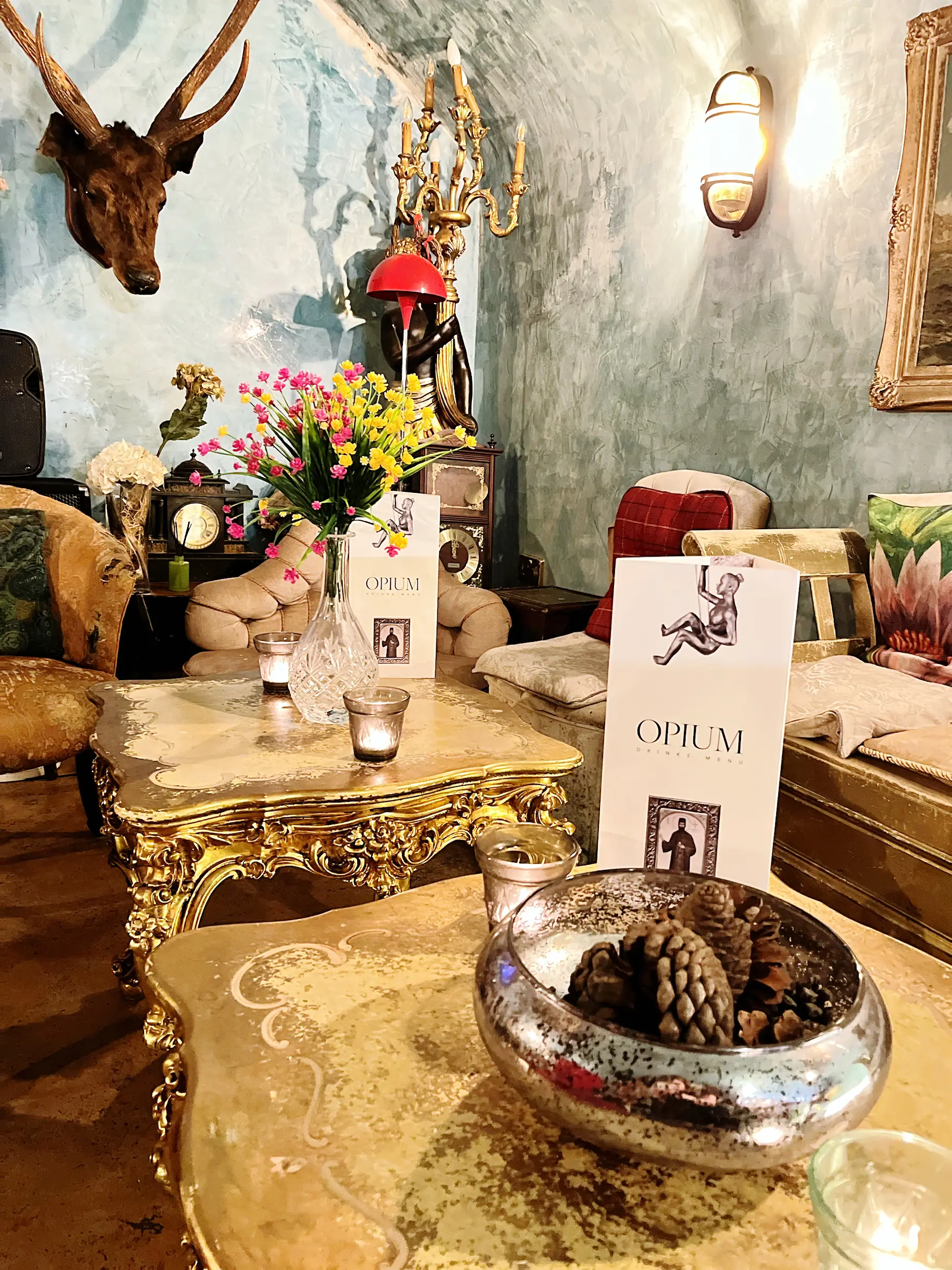 Gilded tables, candles and curiosities in the Opium vaults