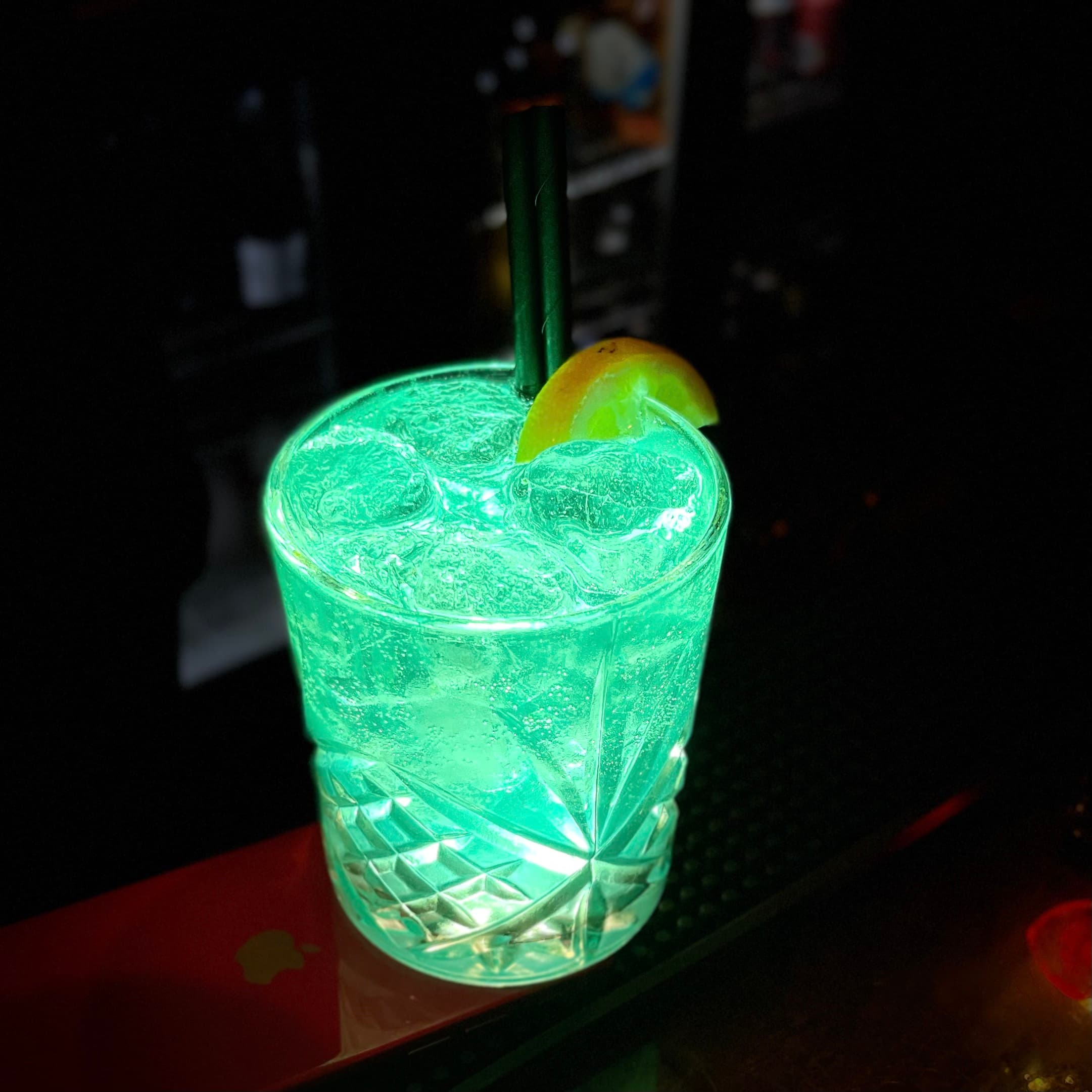 A bespoke Opium serve with botanical garnish in low light.