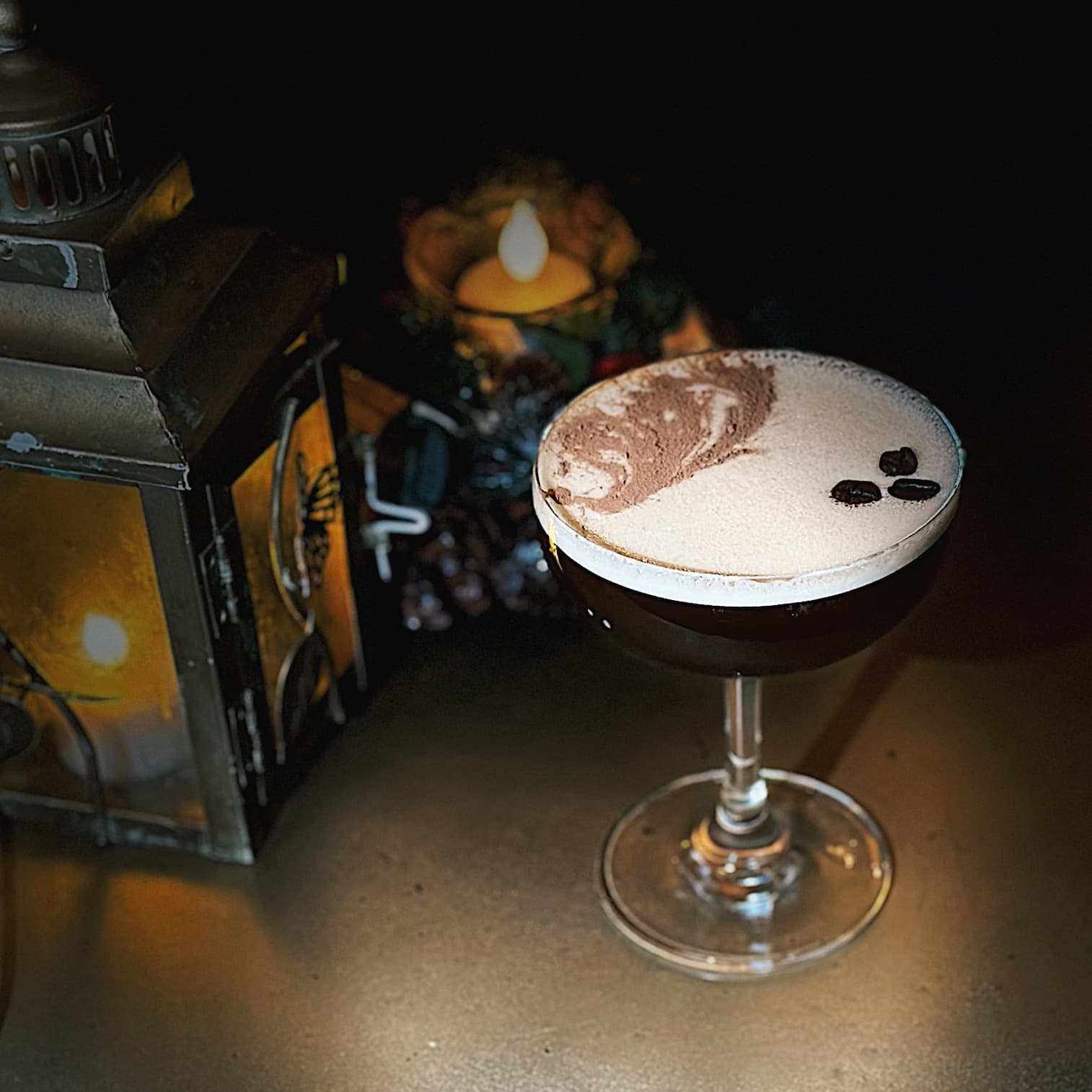 An amber cocktail caught in a single shaft of warm light.